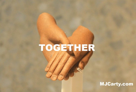 A photograph with the word "Together" superimposed over it. The photograph comes from Wikimedia Commons, where it has the following title: "Holding hands - Egyptian statue - Berlin".